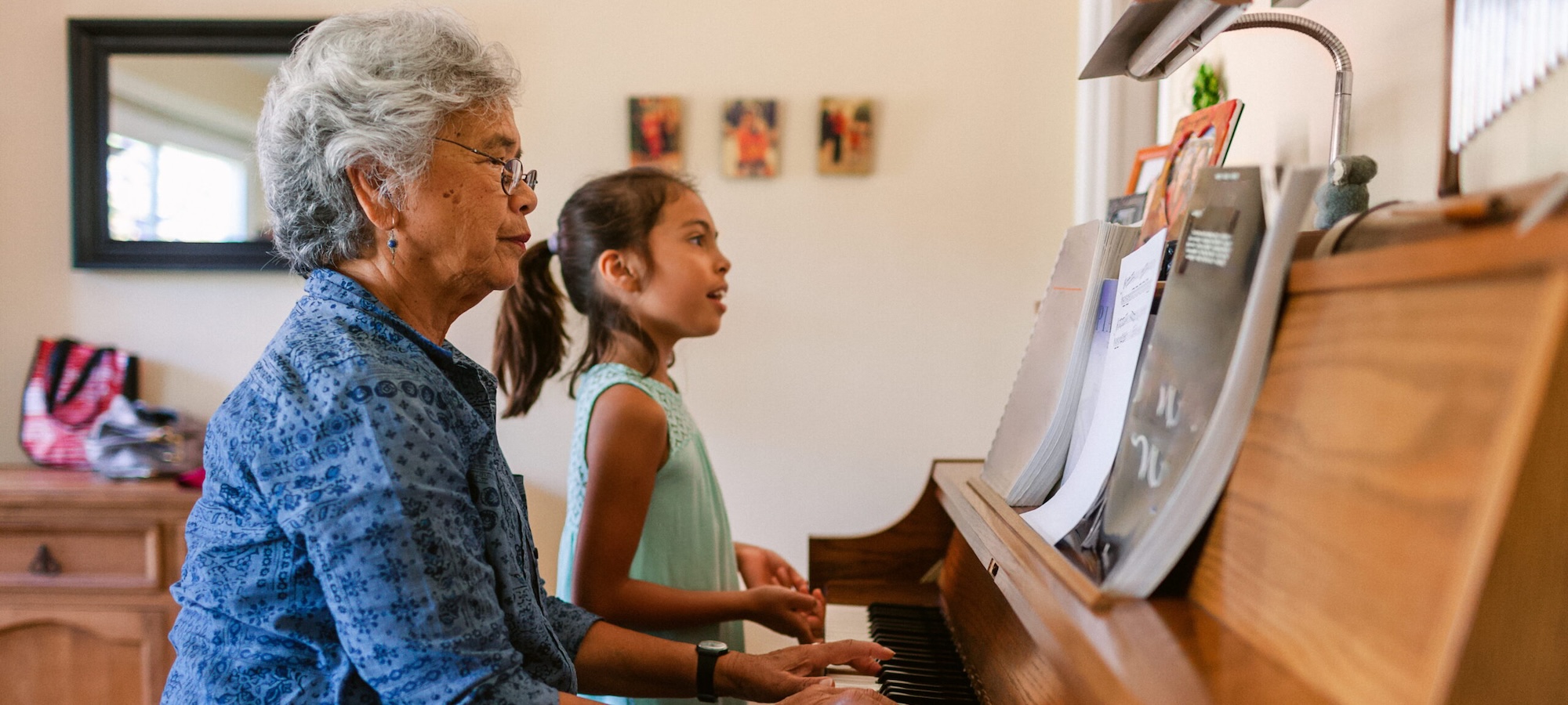 Young girl and her foster carer practice piano